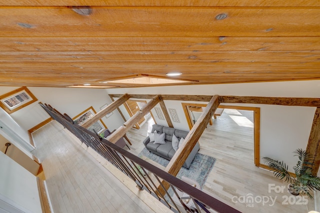 staircase featuring wood-type flooring, wooden ceiling, and vaulted ceiling