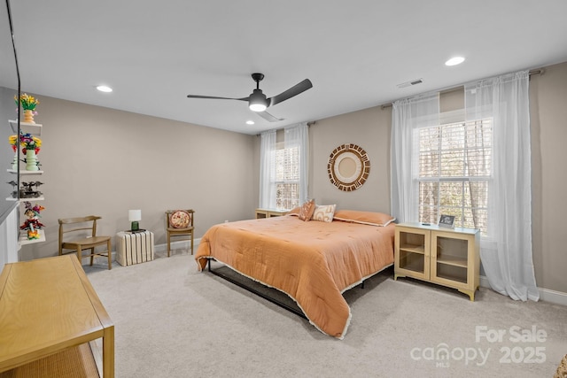 carpeted bedroom featuring multiple windows and ceiling fan