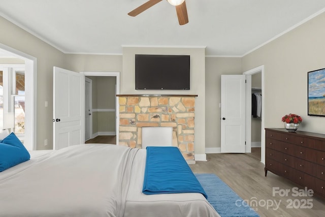 bedroom with ceiling fan, crown molding, light hardwood / wood-style flooring, and a closet