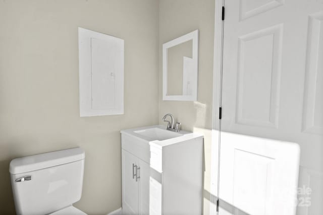 bathroom featuring electric panel, vanity, and toilet