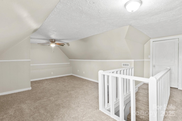 bonus room featuring a textured ceiling, ceiling fan, lofted ceiling, and light colored carpet