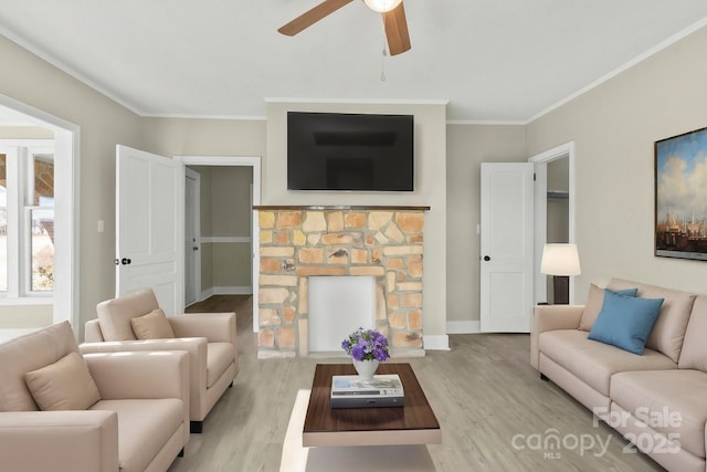 living room with a fireplace, ornamental molding, and light wood-type flooring