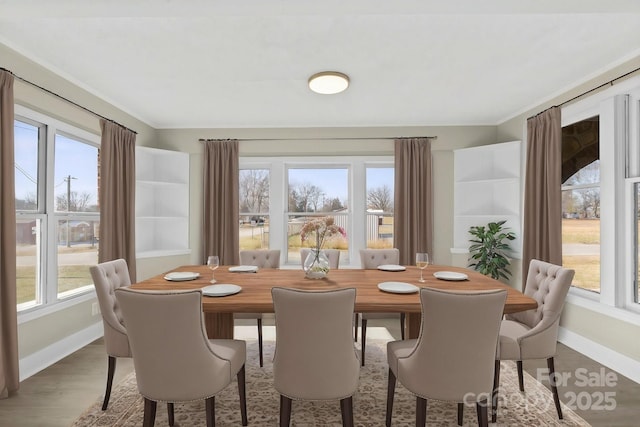 dining area featuring a wealth of natural light, ornamental molding, and hardwood / wood-style flooring