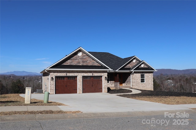 view of front of house with cooling unit, a garage, and a mountain view