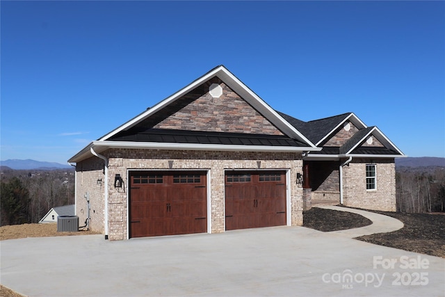 view of front of house featuring a garage, a mountain view, and central air condition unit