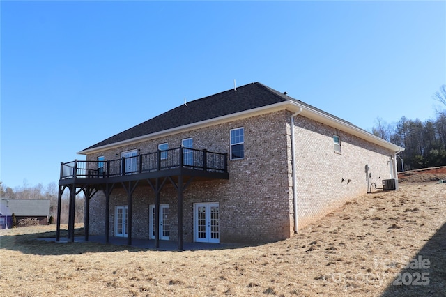 view of side of property featuring a wooden deck, central AC unit, and french doors