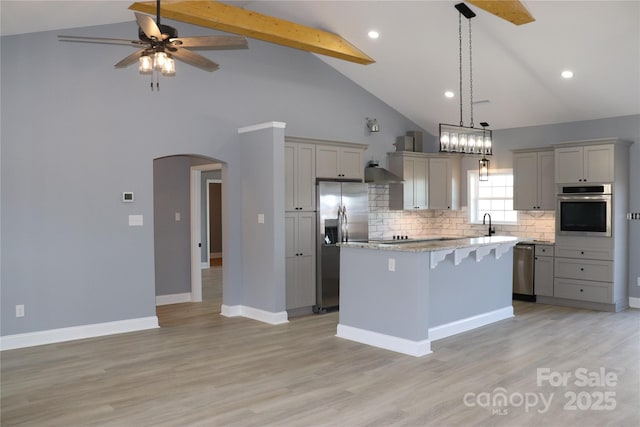 kitchen with gray cabinetry, beam ceiling, stainless steel appliances, and a center island