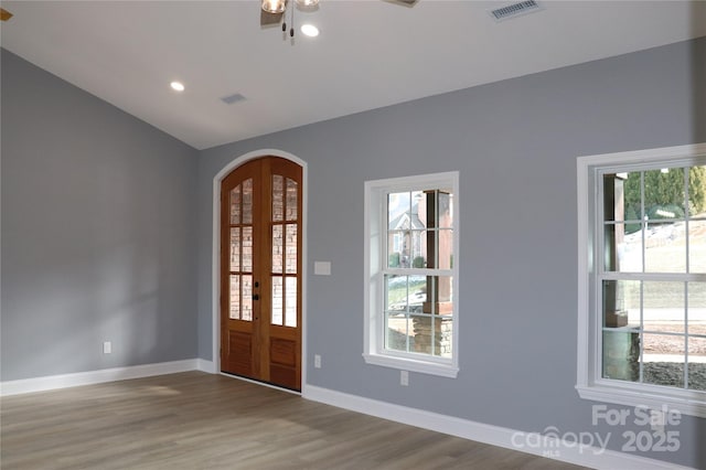 entrance foyer featuring ceiling fan, wood-type flooring, and vaulted ceiling