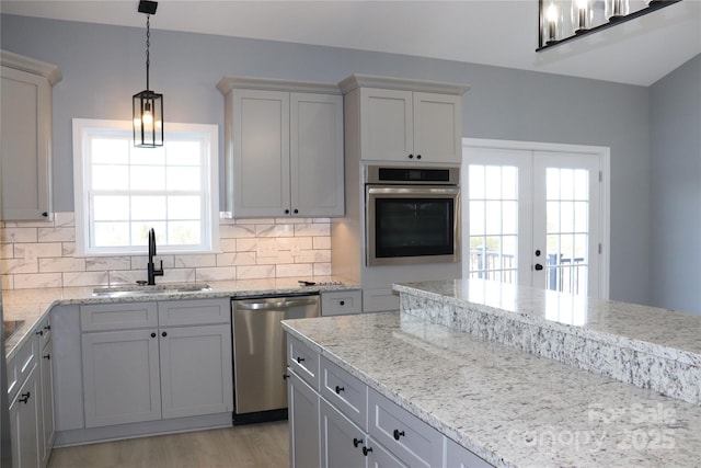 kitchen with sink, decorative backsplash, a healthy amount of sunlight, and appliances with stainless steel finishes