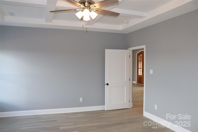 unfurnished room featuring beamed ceiling, ceiling fan, coffered ceiling, and light hardwood / wood-style floors