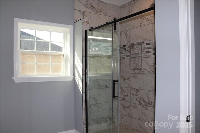 bathroom featuring a shower with door and a wealth of natural light