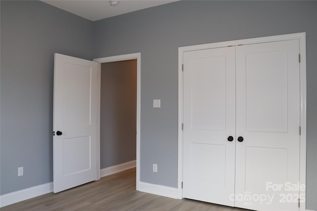 unfurnished bedroom featuring light wood-type flooring and a closet