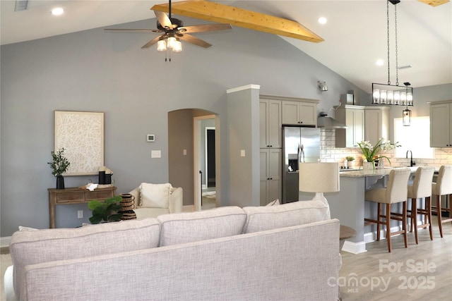 418 Huntington Woods St SE, Lenoir, NC 28645 - living room featuring a ceiling fan, arched walkways, high vaulted ceiling, light wood finished floors, and beamed ceiling