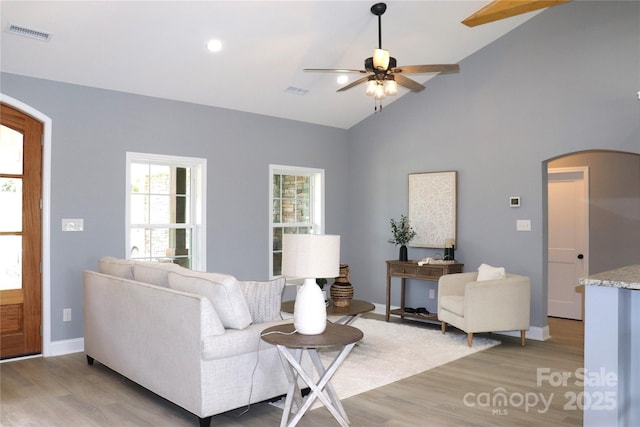418 Huntington Woods St SE, Lenoir, NC 28645 - living room with arched walkways, light wood-style floors, a ceiling fan, baseboards, and high vaulted ceiling