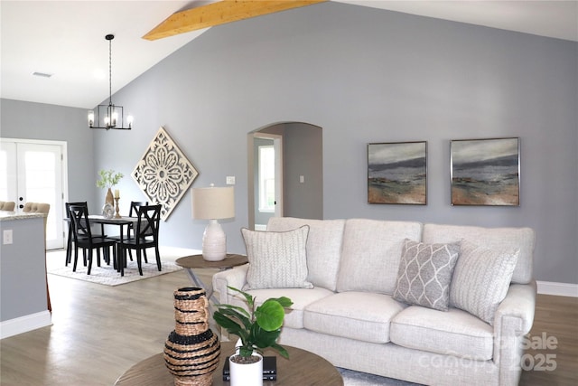 418 Huntington Woods St SE, Lenoir, NC 28645 - living room featuring arched walkways, wood finished floors, a chandelier, baseboards, and beamed ceiling