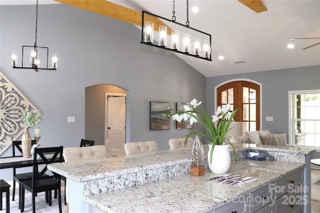 418 Huntington Woods St SE, Lenoir, NC 28645 - kitchen with arched walkways, a chandelier, a center island, vaulted ceiling, and light stone countertops
