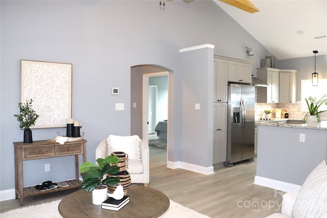 418 Huntington Woods St SE, Lenoir, NC 28645 - kitchen featuring stainless steel fridge with ice dispenser, arched walkways, backsplash, high vaulted ceiling, and light wood finished floors