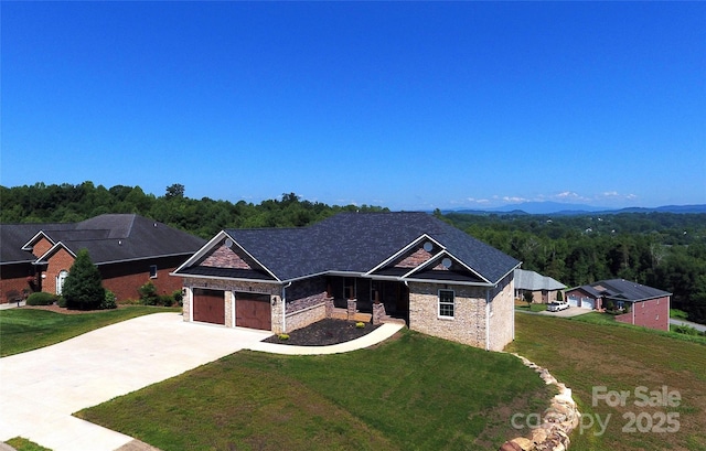418 Huntington Woods St SE, Lenoir, NC 28645 - view of front facade featuring driveway, a front lawn, a garage, and a wooded view