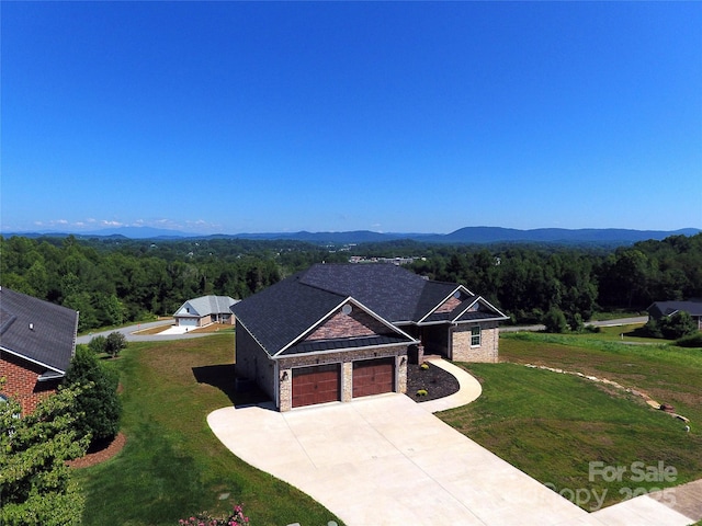 418 Huntington Woods St SE, Lenoir, NC 28645 - view of front of home with a wooded view, a garage, a front yard, and driveway