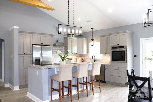 418 Huntington Woods St SE, Lenoir, NC 28645 - kitchen with appliances with stainless steel finishes, backsplash, a center island, light wood-type flooring, and lofted ceiling