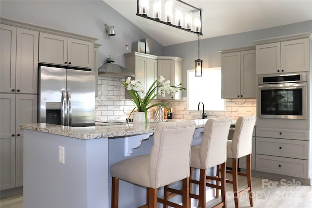 418 Huntington Woods St SE, Lenoir, NC 28645 - kitchen featuring appliances with stainless steel finishes, tasteful backsplash, light stone countertops, decorative light fixtures, and a breakfast bar area