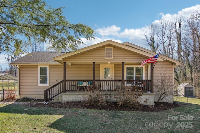 view of front facade featuring a front lawn, a storage unit, and a porch