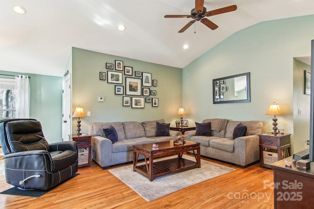 living room featuring ceiling fan, lofted ceiling, and light hardwood / wood-style floors