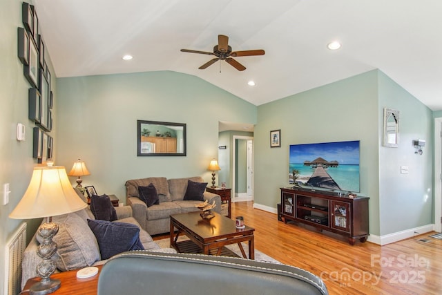 living room featuring light hardwood / wood-style floors, ceiling fan, and vaulted ceiling