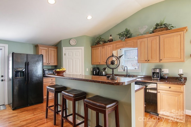 kitchen with sink, light hardwood / wood-style floors, a center island, and black appliances