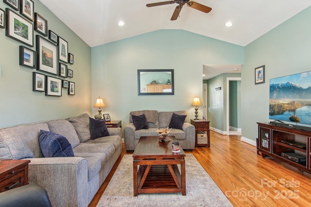 living room with ceiling fan, light hardwood / wood-style flooring, and lofted ceiling