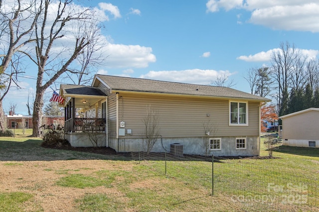 rear view of house with covered porch, cooling unit, and a yard