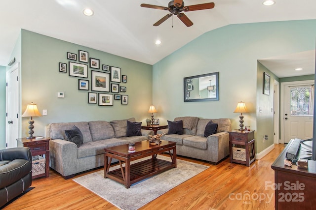 living room featuring ceiling fan, light wood-type flooring, and vaulted ceiling