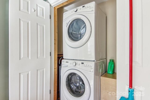 clothes washing area featuring stacked washer and clothes dryer