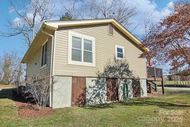 view of home's exterior featuring a lawn, cooling unit, and a deck