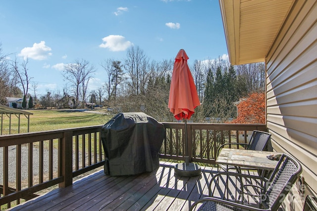 deck featuring a grill and a lawn