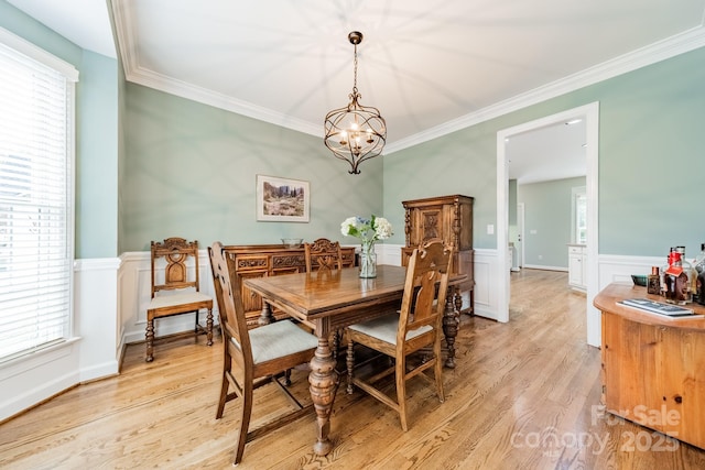 dining room with crown molding, a healthy amount of sunlight, and light hardwood / wood-style flooring