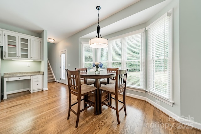 dining room featuring built in desk and light hardwood / wood-style floors