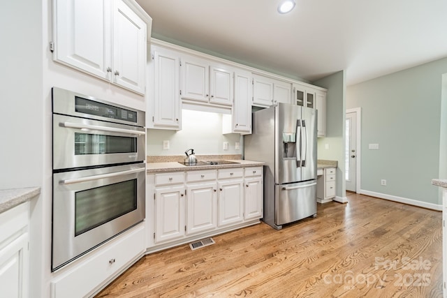 kitchen featuring white cabinetry, light hardwood / wood-style floors, and appliances with stainless steel finishes