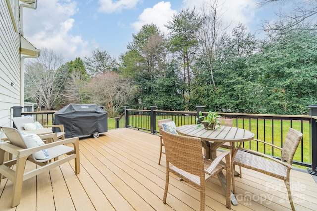 wooden deck with grilling area and a lawn