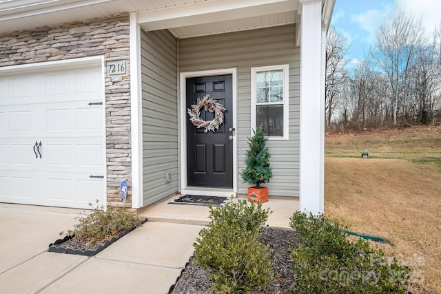 property entrance featuring a garage and a yard