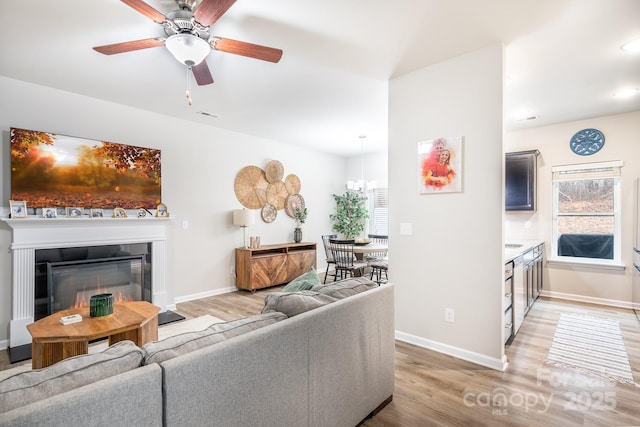 living room featuring hardwood / wood-style flooring and ceiling fan with notable chandelier