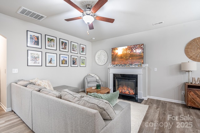 living room with hardwood / wood-style floors and ceiling fan