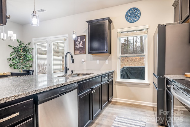 kitchen with stainless steel appliances, a healthy amount of sunlight, hanging light fixtures, and sink