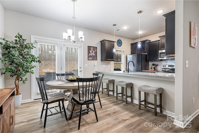 dining area featuring an inviting chandelier and light hardwood / wood-style floors