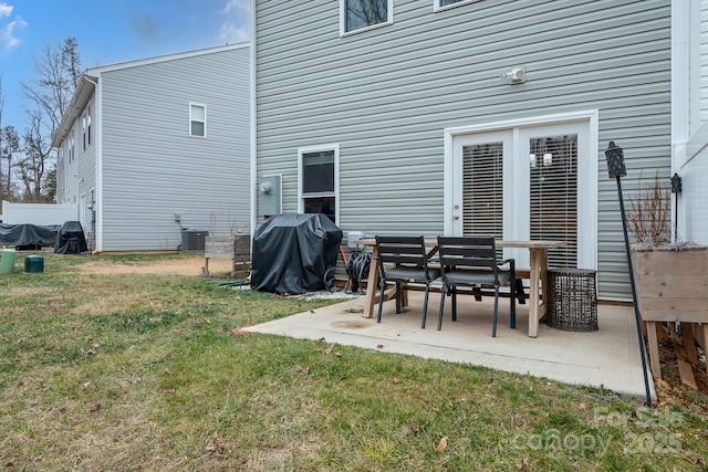 back of property featuring a yard, cooling unit, and a patio area