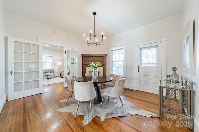 dining area featuring french doors, hardwood / wood-style floors, and a notable chandelier