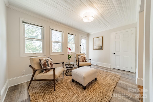 living area featuring wood ceiling, ornamental molding, and light hardwood / wood-style floors