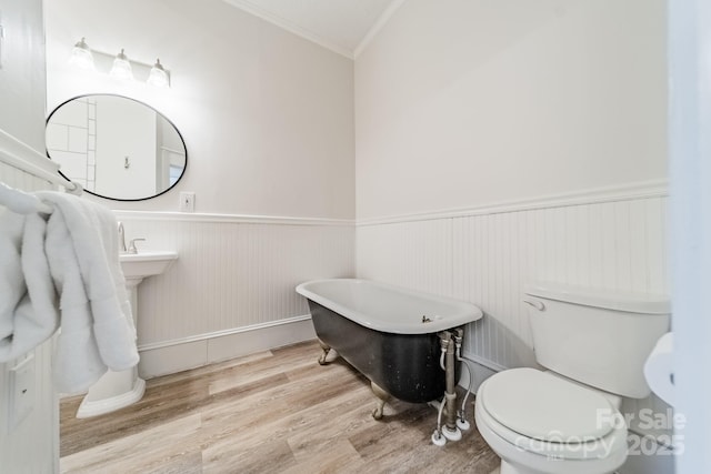 bathroom with toilet, crown molding, a bathtub, and hardwood / wood-style floors