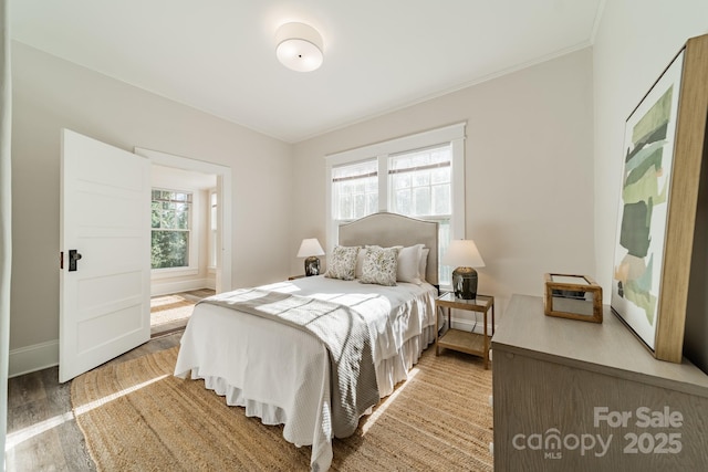 bedroom with wood-type flooring and multiple windows