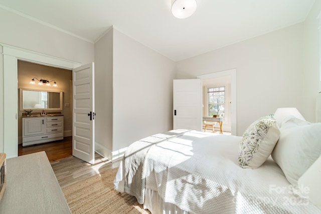 bedroom with ornamental molding and light hardwood / wood-style flooring